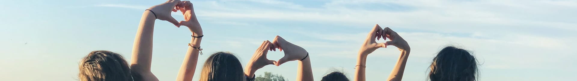 Group of people forming hearts with their hands